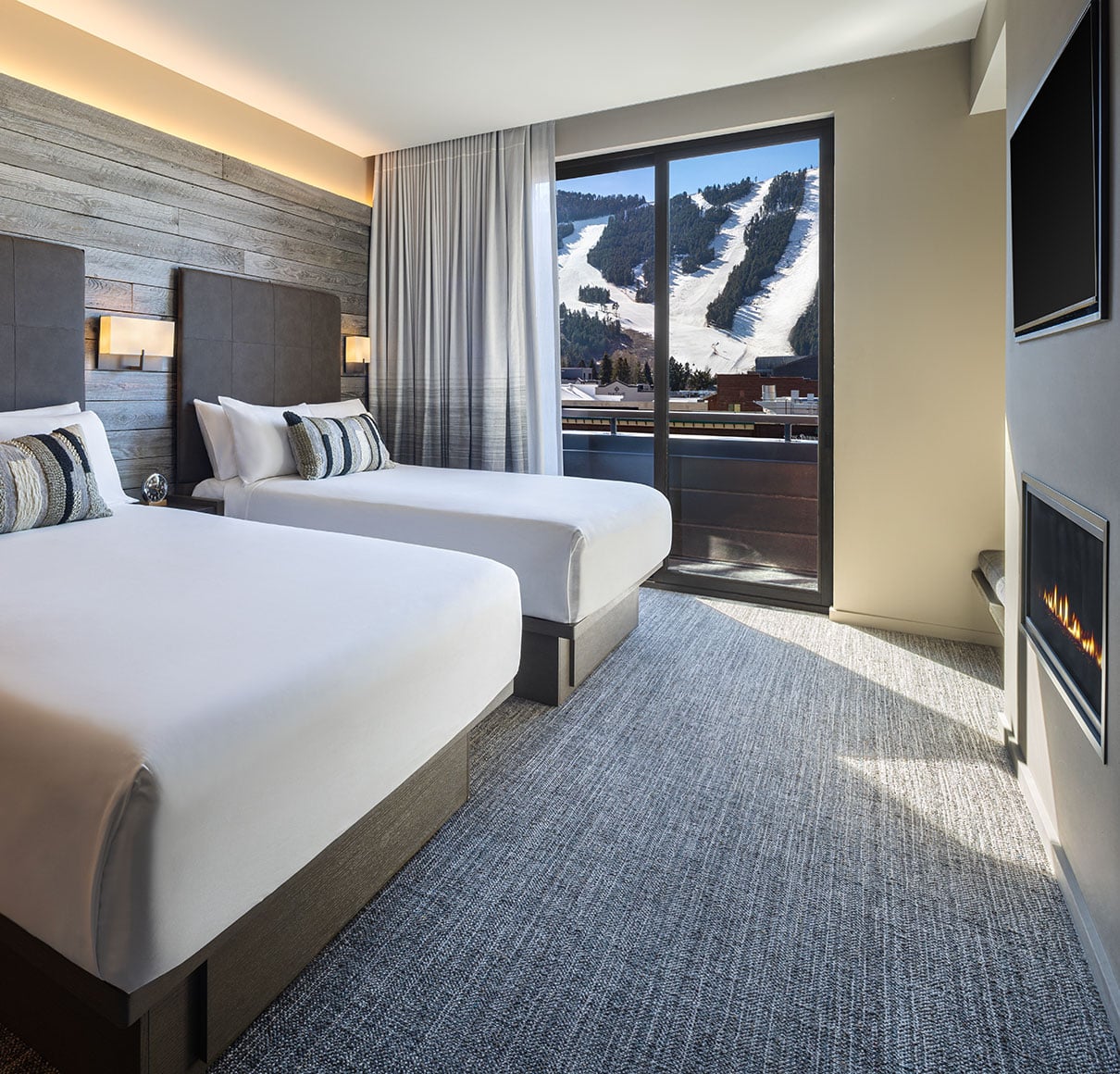 Luxury guest room at Hotel Jackson with two queen beds, gas fireplace, and Snow King Mountain view